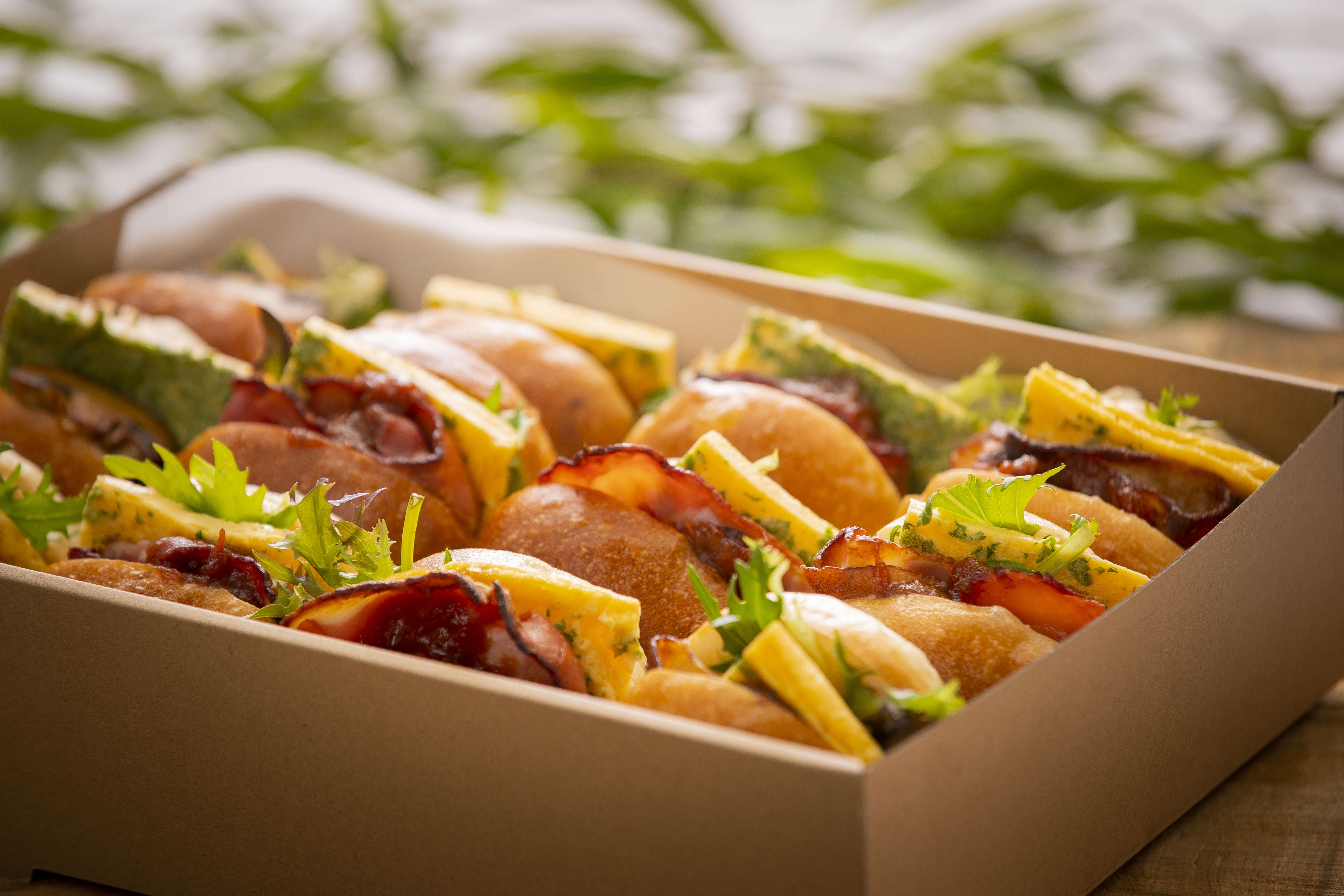 Catering box containing twelve breakfast rolls including some egg and bacon with tomato relish rolls, and some egg and mushroom with tomato relish rolls. Photo: Richard Jupe.