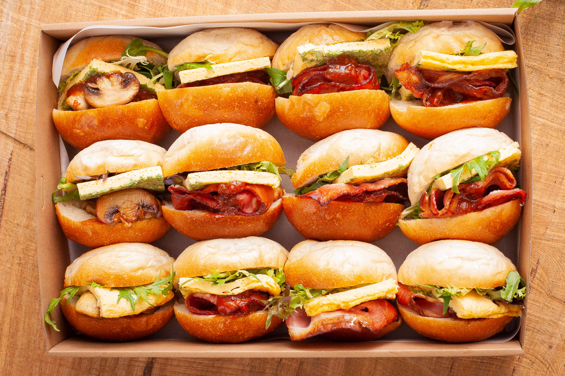 Catering box containing twelve breakfast rolls including some egg and bacon with tomato relish rolls, and some egg and mushroom with tomato relish rolls. Credit: Richard Jupe.