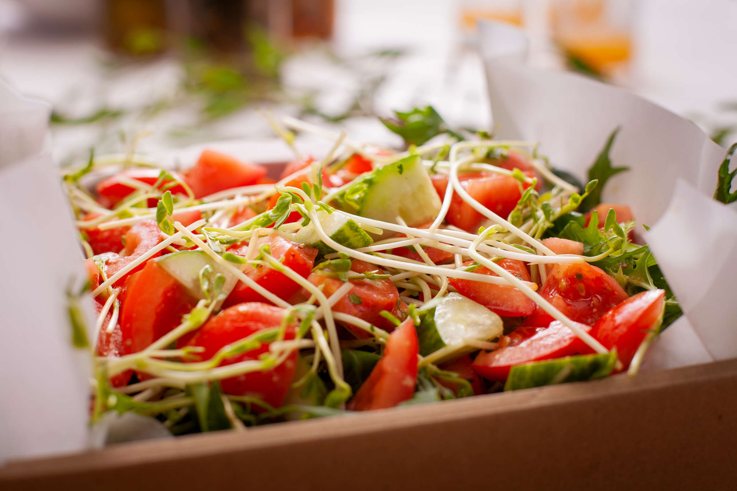 Garden salad catering box including lettuce, tomato, cucumber, and vinaigrette dressing. Credit: Richard Jupe.